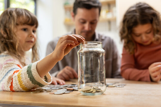 Kids Counting Coins in a Glass Jar Together