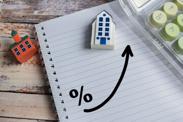 Financial concept of high mortgage interest rates write on book isolated on Wooden Table.