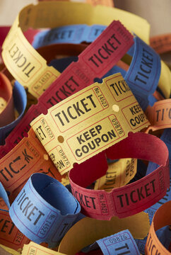 Colorful retro paper raffle tickets rolled and stacked for event entry and prize draws.