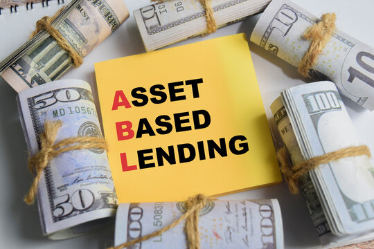 Concept of asset based lending write on sticky notes isolated on Wooden Table.