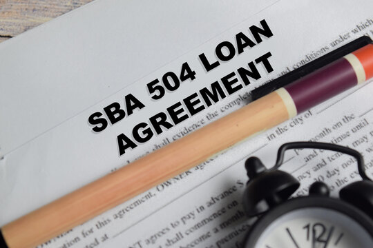 Concept of SBA 504 loan agreement write on document isolated on Wooden Table.