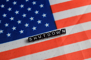 Concept of text shutdown and USA flag on wooden blocks.