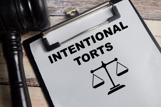 Concept of intentional torts write on clipboard isolated on Wooden Table.