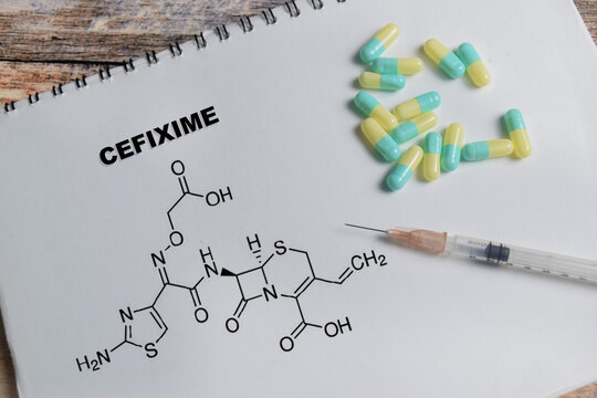 Concept of chemical structure cefixime write on book isolated on Wooden Table.