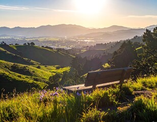 Scenic vista of rolling hills, mountains, and a distant town, bathed in warm sunlight. A wooden bench sits on a grassy overlook