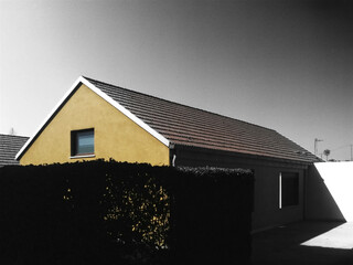 Yellow House with Dark Hedge and Clear Sky Keywords: house, architecture, residential, building