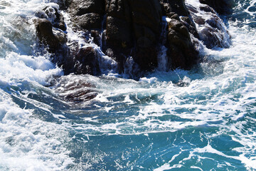 Beach by the sea with foam and spray from the waves