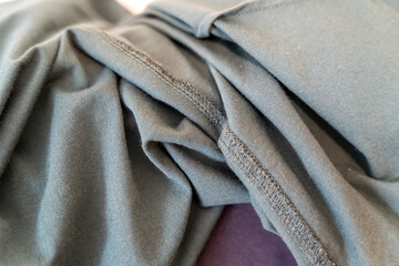A detailed close-up of folded dark green fabric, showcasing texture and fabric quality. Ideal for fashion, textile design, or product promotion focusing on cloth materials.