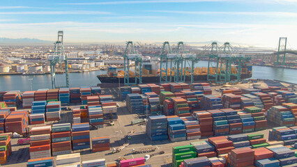 DRONE: Flying over colorful freight containers and a large docked cargo ship