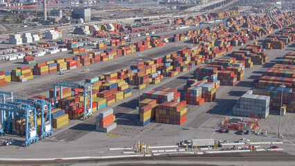 AERIAL: Cool flying view of a busy commercial port near a metropolitan city.