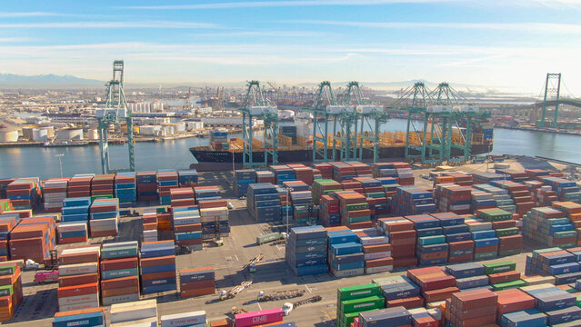 DRONE: Flying over colorful freight containers and a large docked cargo ship