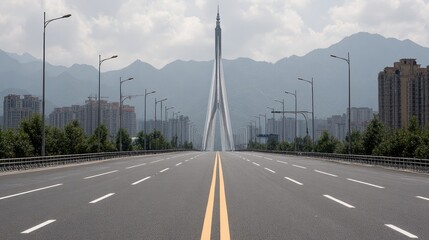 A wide, empty road leads toward a striking modern bridge with towering cables, surrounded by mountains and a sparse urban landscape, ideal for showcasing infrastructure and urban development themes,