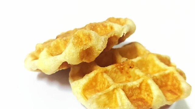Delicious, freshly baked traditional Belgian (Liege) waffles isolated on white, a perfect sweet treat for breakfast or dessert.