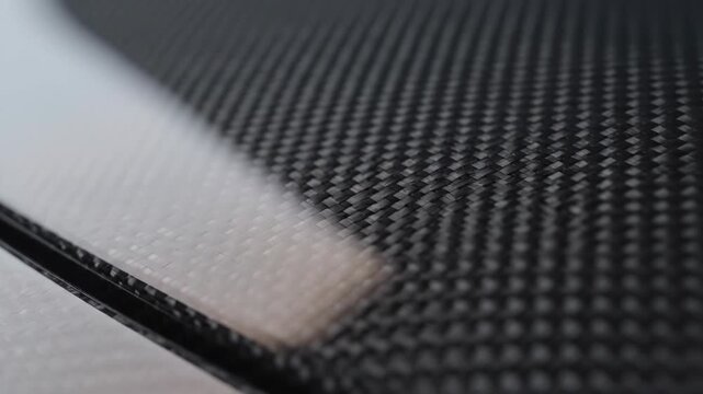 Closeup view of a black carbon fiber texture with a blurred background