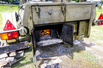 Field kitchen for cooking camp food. Bright fire burns in the stove of a field kitchen