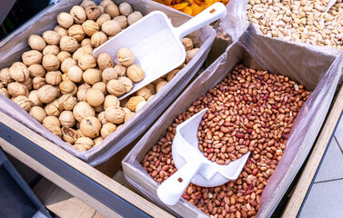 Unpeeled walnuts and peanut are sold in a grocery store