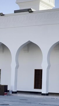 Close-up of the pristine white arches, dark wooden doors, and intricate latticework windows of Masjid Al-Areesh in Badr, showcasing traditional Saudi architectural heritage.