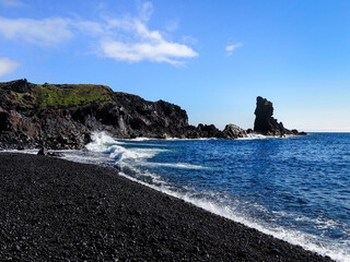 Dj&uacute;pal&oacute;nssandur beach. Located on southern coast of the Sn&aelig;fellsnes Peninsula, western Iceland. Basalt rock formations and black wet sand and pebbles. Blue Atlantic ocean with crushing sneaker waves.