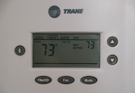 Florida, U.S.A - Jan 2, 2026 - Trane thermostat set to heat mode at 73&deg;F, with fan on and energy-saving options visible.
