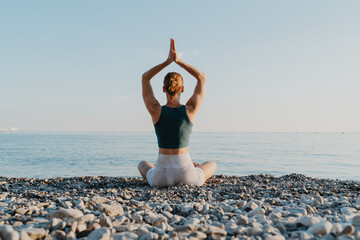 Woman meditating and breathing at seaside at sunset or sunrise. Holistic Health and Mental Well-Being.