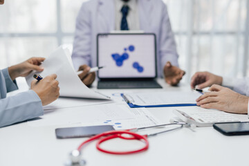 Medical professionals and administrators collaborating on medical data analysis with tablets and paperwork, calculating costs amidst stethoscopes and smartphones.