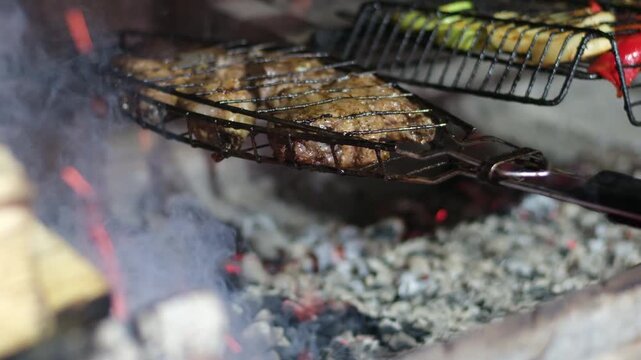 Grilling shashlik kebab on barbecue grill outdoors. Preparing juicy meat kebab on skewer in smoke. BBQ. Grill outdoors. Picnic time
