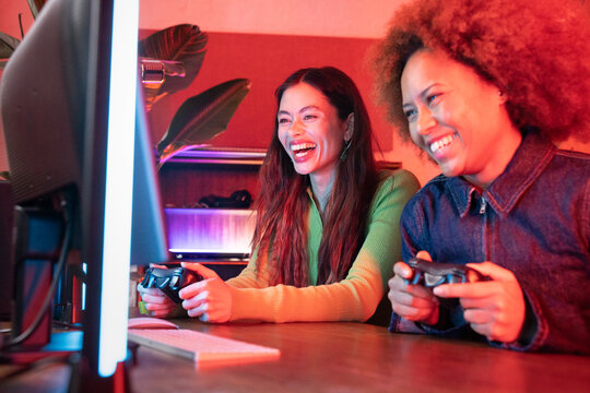 Women playing video games at home setup