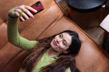 Young Woman Taking a Selfie on a Sofa