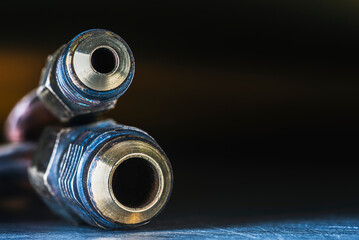 Used brass threaded fittings with copper pipes, used in refrigeration systems, close-up view in an industrial setting