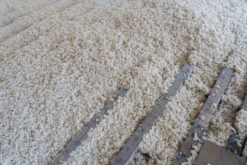 Texture naturelle de laine d'isolation brute pour la rénovation d'une maison et l'amélioration énergétique d'un sol, doux et fibreuse, évoquant authenticité, artisanat et matières textiles naturelles. © Thomas