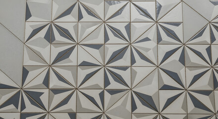 Close-up of modern tile design with geometric patterns in gray, white, and a slight golden accent, creating a 3D effect
