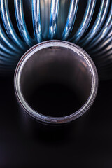 Products of the metallurgical industry, a steel spring and an aluminum tube, metal structure and stresses, close-up view in an industrially lit environment