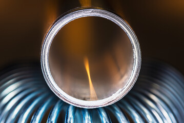 Products of the metallurgical industry, a steel spring and an aluminum tube, metal structure and stresses, close-up view in an industrially lit environment