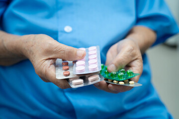 Asian elderly woman holding pill drug in hand, strong healthy medical concept.