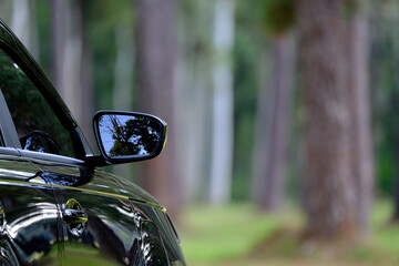 Electric Car Side Mirror Reflecting Forest Nature, Sustainable Future Electric Vehicle Background Image