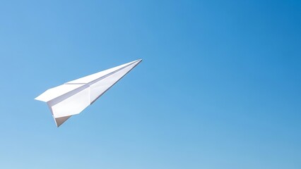 Fototapeta premium A white paper airplane soaring high in a clear blue sky from a low-angle viewpoint