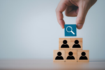 Hand selecting search icon above people blocks representing talent search recruitment employee...