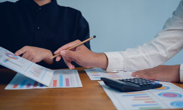 Business people analyzing financial reports with charts, graphs and calculator on desk, professional teamwork concept for financial analysis, budgeting, planning, audit, strategy and decision making. - Powered by Adobe