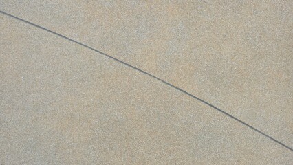 The walkway surface is made of exposed aggregate concrete with beige, gray, and light brown stones. The naturally rough surface is distinguished by curved gray grout lines.