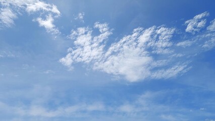 Obraz premium Beautiful white clouds in a clear blue sky. Bright blue sky background with soft clouds. The sky is filled with fluffy white clouds.