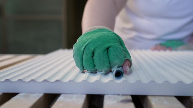 Furniture factory worker sanding corrugated mdf panel by hand