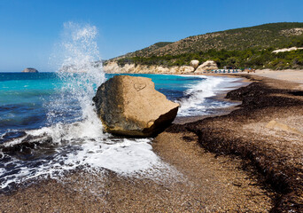 Fale rozbijające się o skałę na dzikiej plaży w Grecji – turkusowe morze i malownicze wybrzeże Rodos © adr77