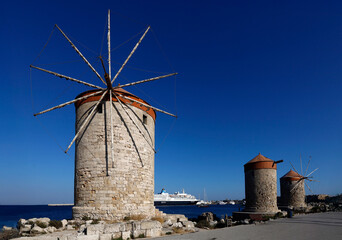 Zabytkowe średniowieczne wiatraki w porcie Mandraki na Rodos – klasyczna architektura grecka nad brzegiem morza © adr77