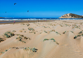 Szeroka piaszczysta plaża Prasonisi na Rodos z wydmami i kitesurferami na tle błękitnego morza © adr77