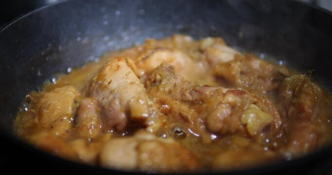 Stewed chicken with onions. Cooking a delicious dinner in a frying pan. Fried meat.