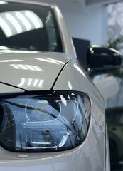 Vertical Detailed Image of a New Vehicle Headlight in a Modern Car Store  
