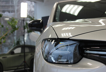 Panoramic Stock Photo of Front Lens Light of a New Car in a Dealership 
