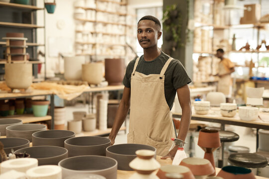 Young African potter standing by a table in a ceramics workshop