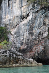Limestone cliffs show signs of erosion by seawater or rain over a long period of time. The beautifully colored limestone cliffs contrast with the blue sea, Phang Nga Bay National Park. Unique landscap
