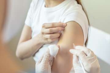 woman getting a vaccination to prevent pandemic. receive a dose of immunization virus vaccine from a nurse or doctor at the medical center, basic vaccine, alternative vaccine, vaccine for risk group